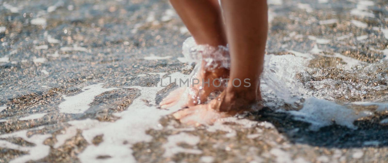 A woman walks along the beach, legs close-up. Barefoot woman sta by panophotograph