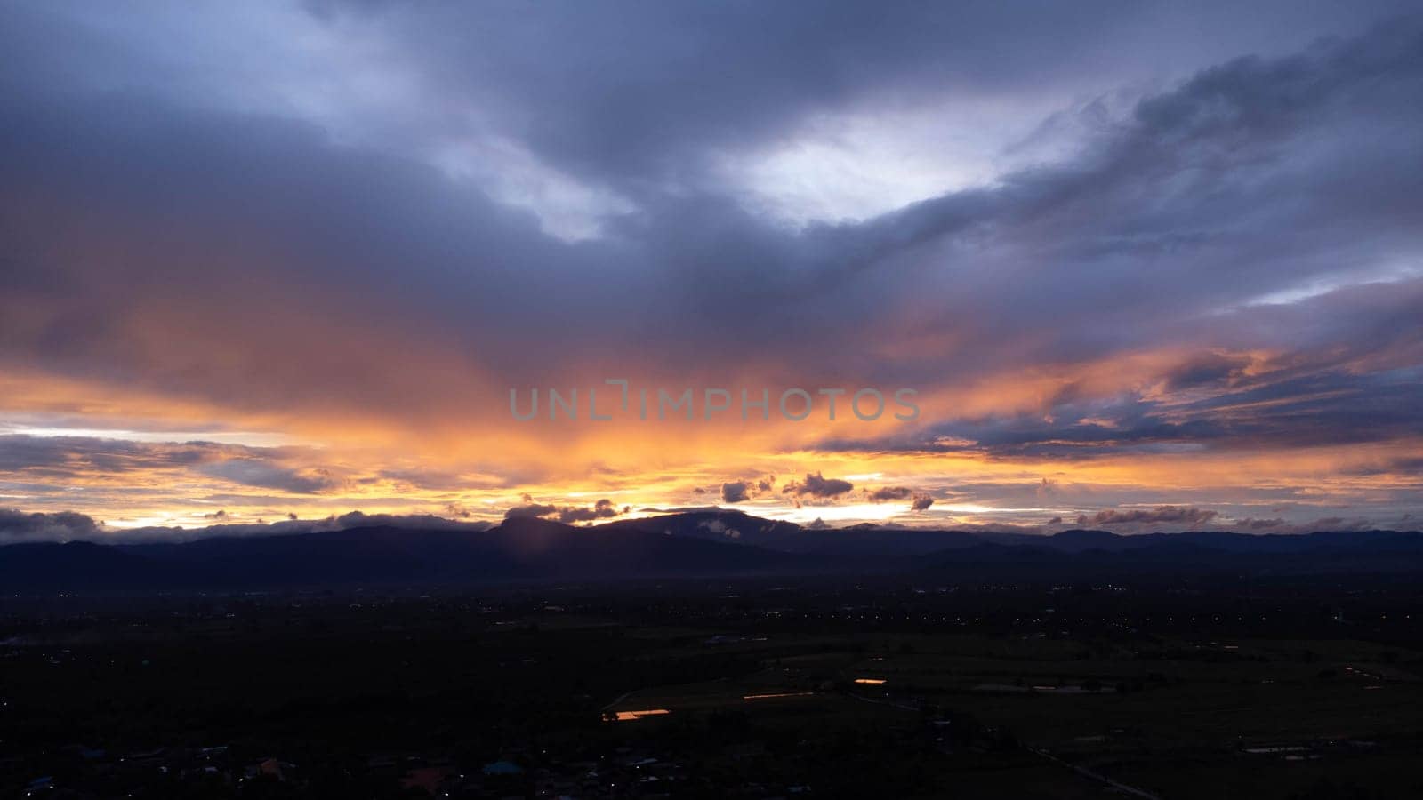 Real amazing sunrise or sunset sky with gentle colorful clouds. Beautiful natural sunset of the mountain range under colorful blue and orange sunset in the evening. by TEERASAK