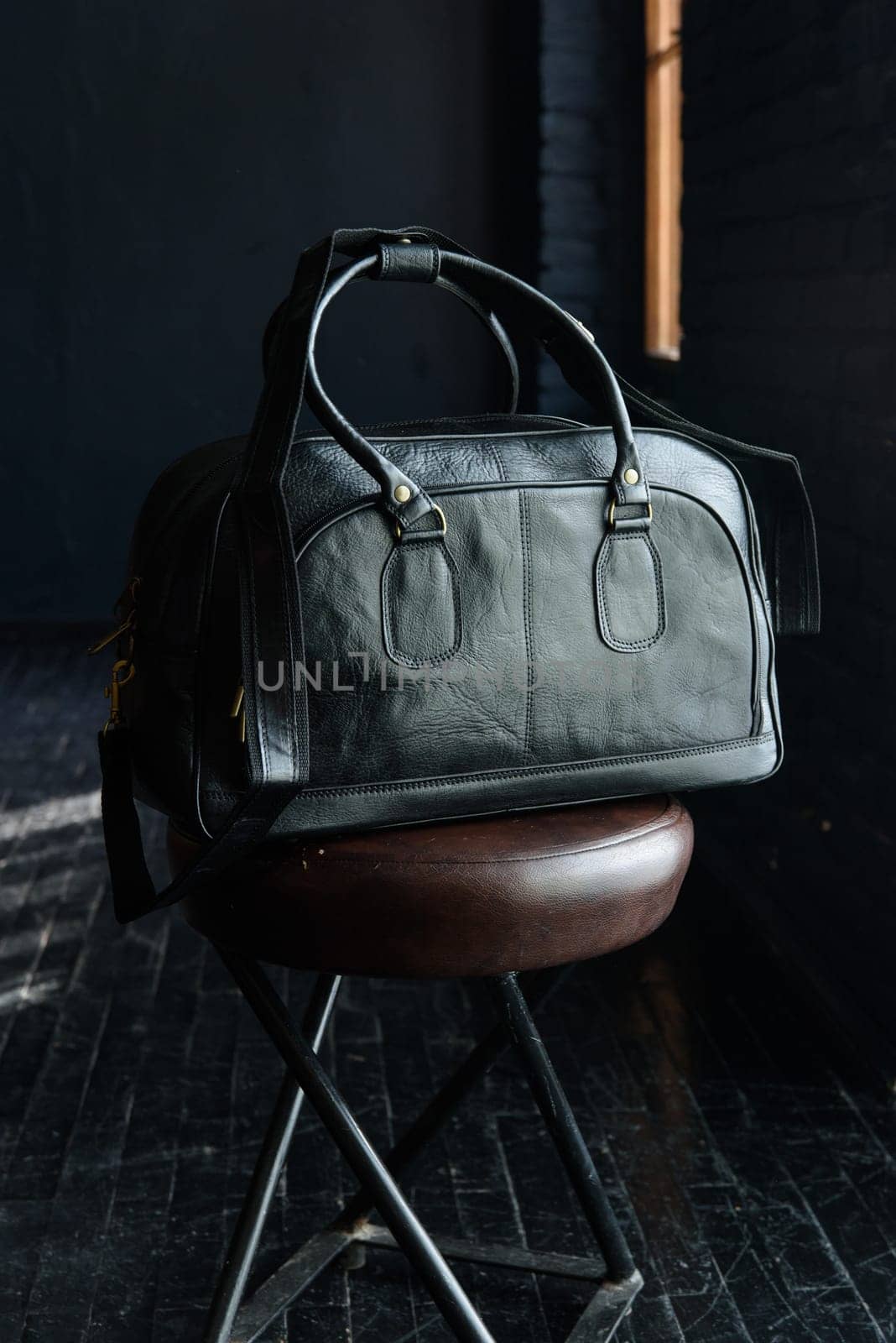 black leather travel bag indoors photo on black background by Ashtray25