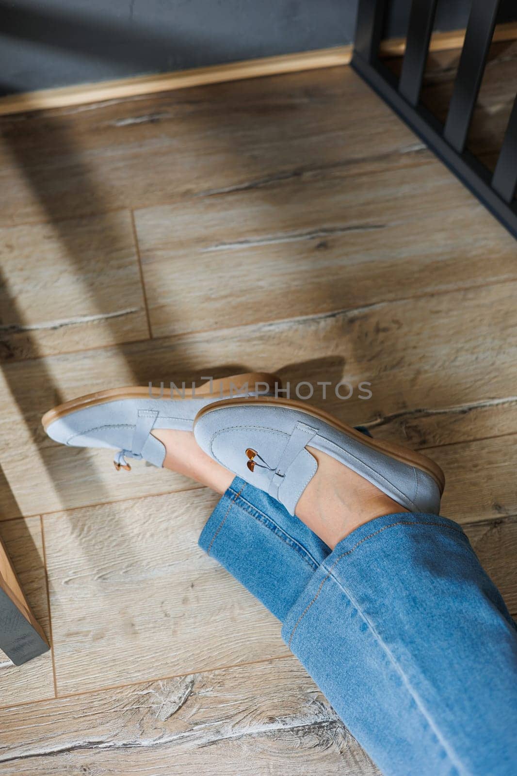 Slender female legs in jeans and blue loafers. Collection of summer women's shoes. Stylish women's shoes for summer