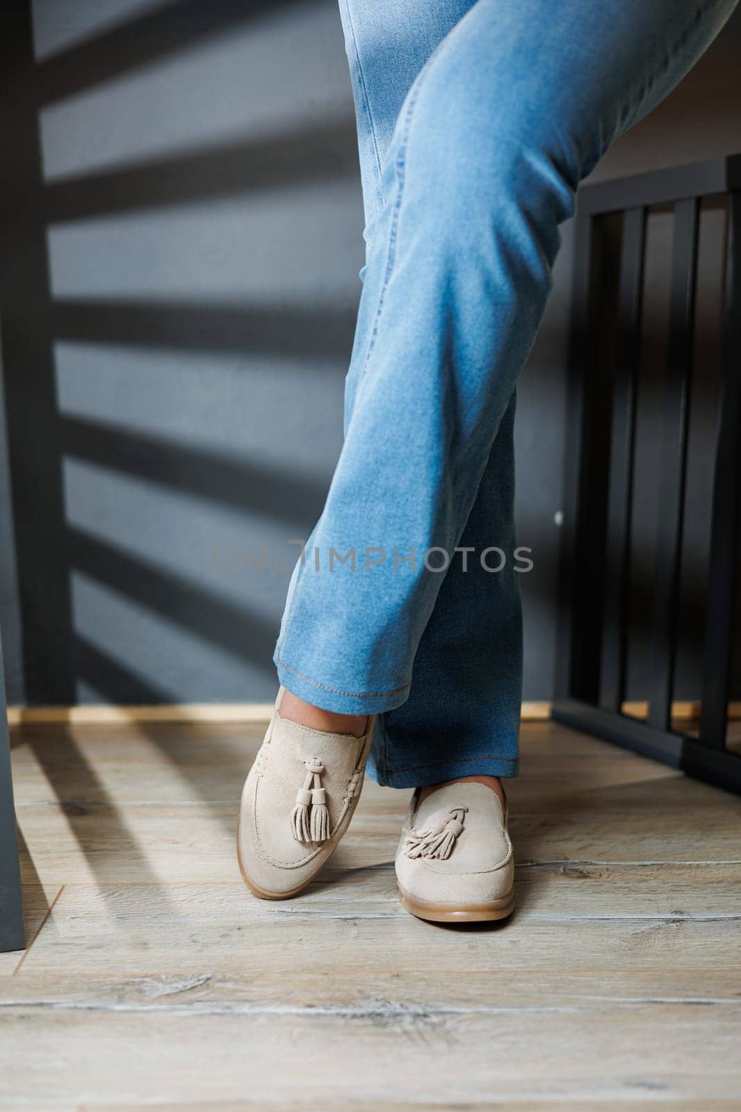 Slender female legs in jeans and beige loafers. Collection of summer women's shoes. Stylish women's shoes for summer
