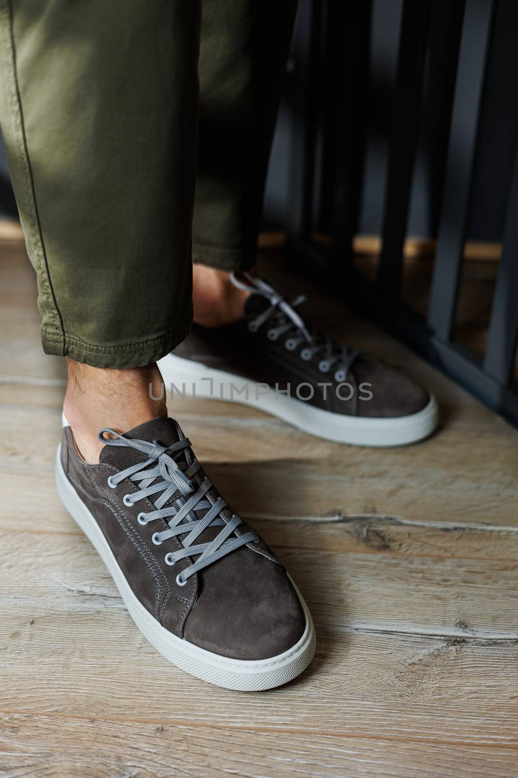 Close-up of male legs in pants and gray casual sneakers. Men's leather shoes. Collection of men's stylish summer shoes by Dmitrytph