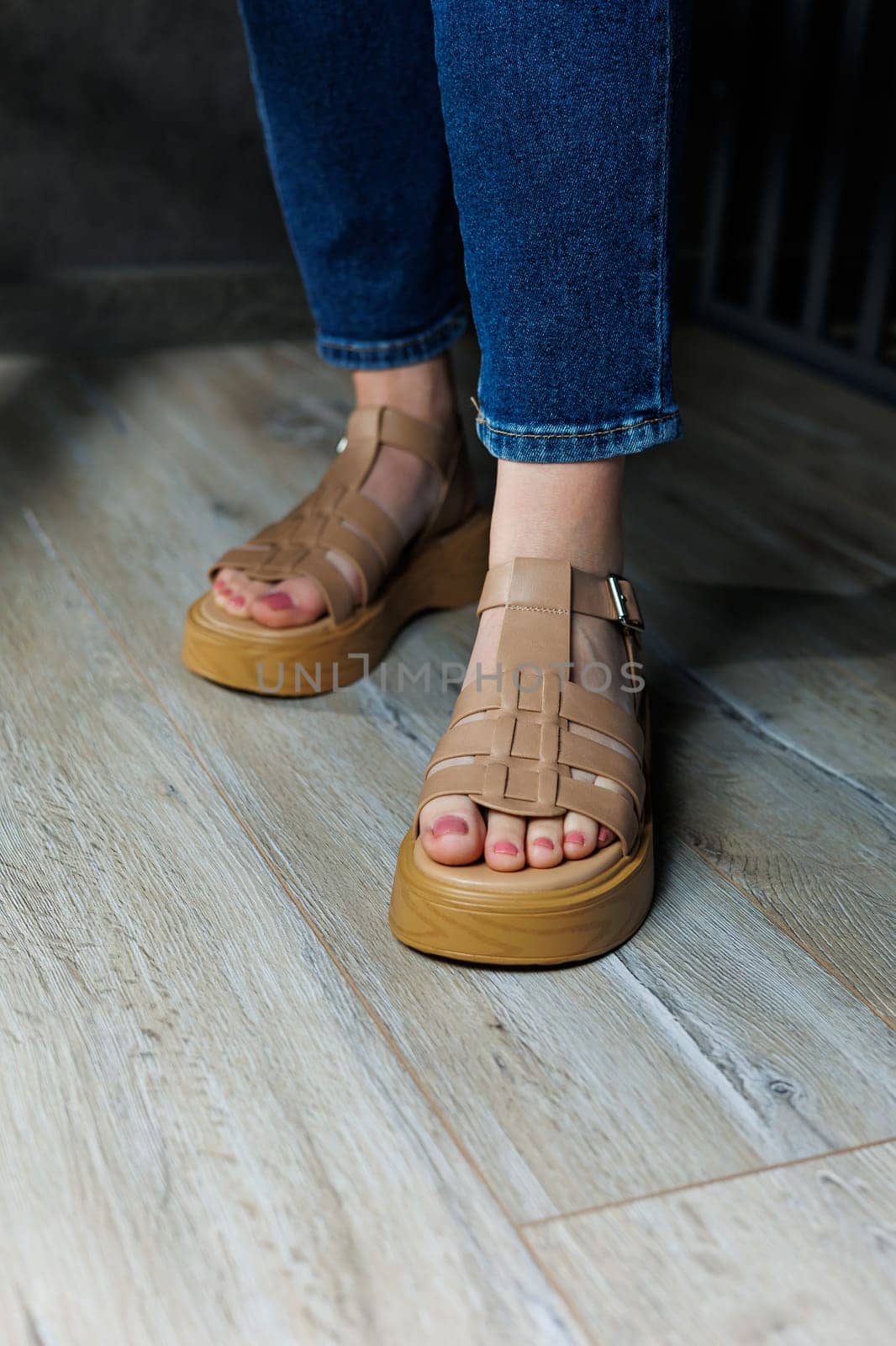 Women's sandals. Female feet close-up in casual brown sandals. Collection of summer women's sandals