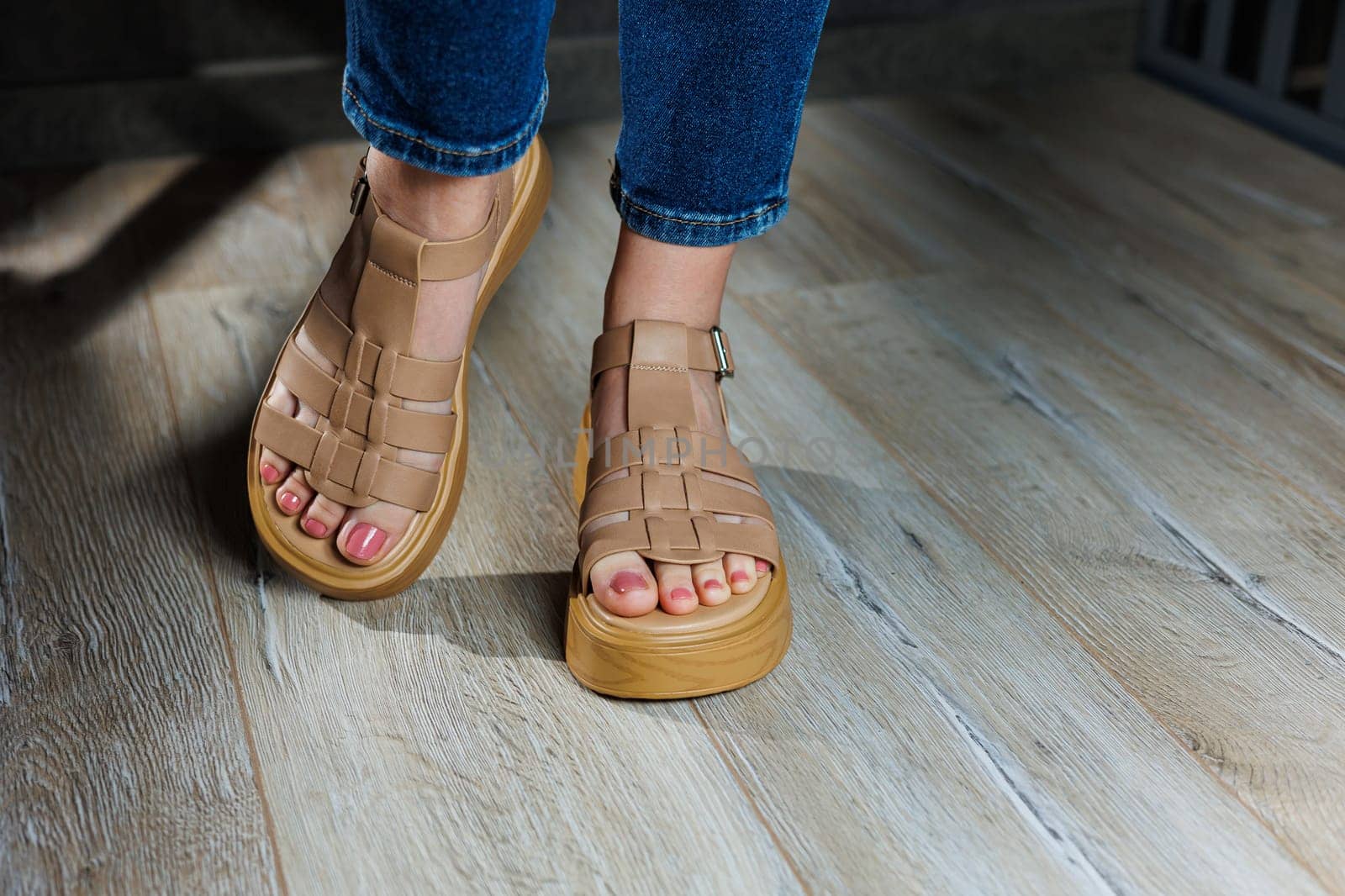 Women's sandals. Female feet close-up in casual brown sandals. Collection of summer women's sandals by Dmitrytph