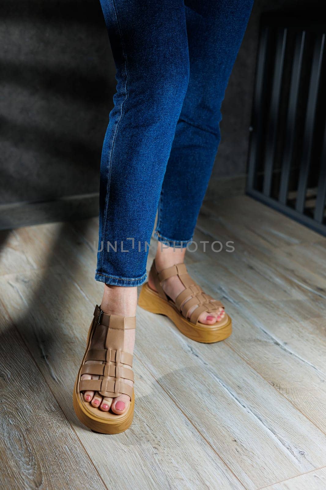 Women's sandals. Female feet close-up in casual brown sandals. Collection of summer women's sandals