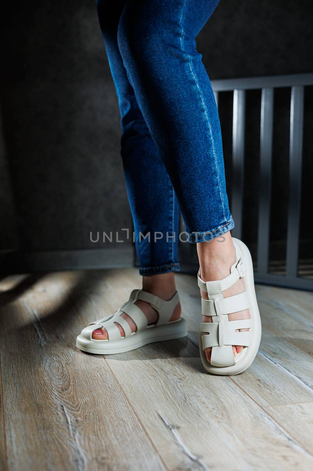 Slender female legs in beige leather sandals without heels. Collection of women's summer sandals. by Dmitrytph