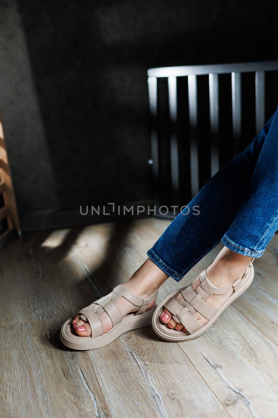 Summer women's sandals. Collection of women's leather summer sandals. Slender female legs in beige leather sandals without heels.