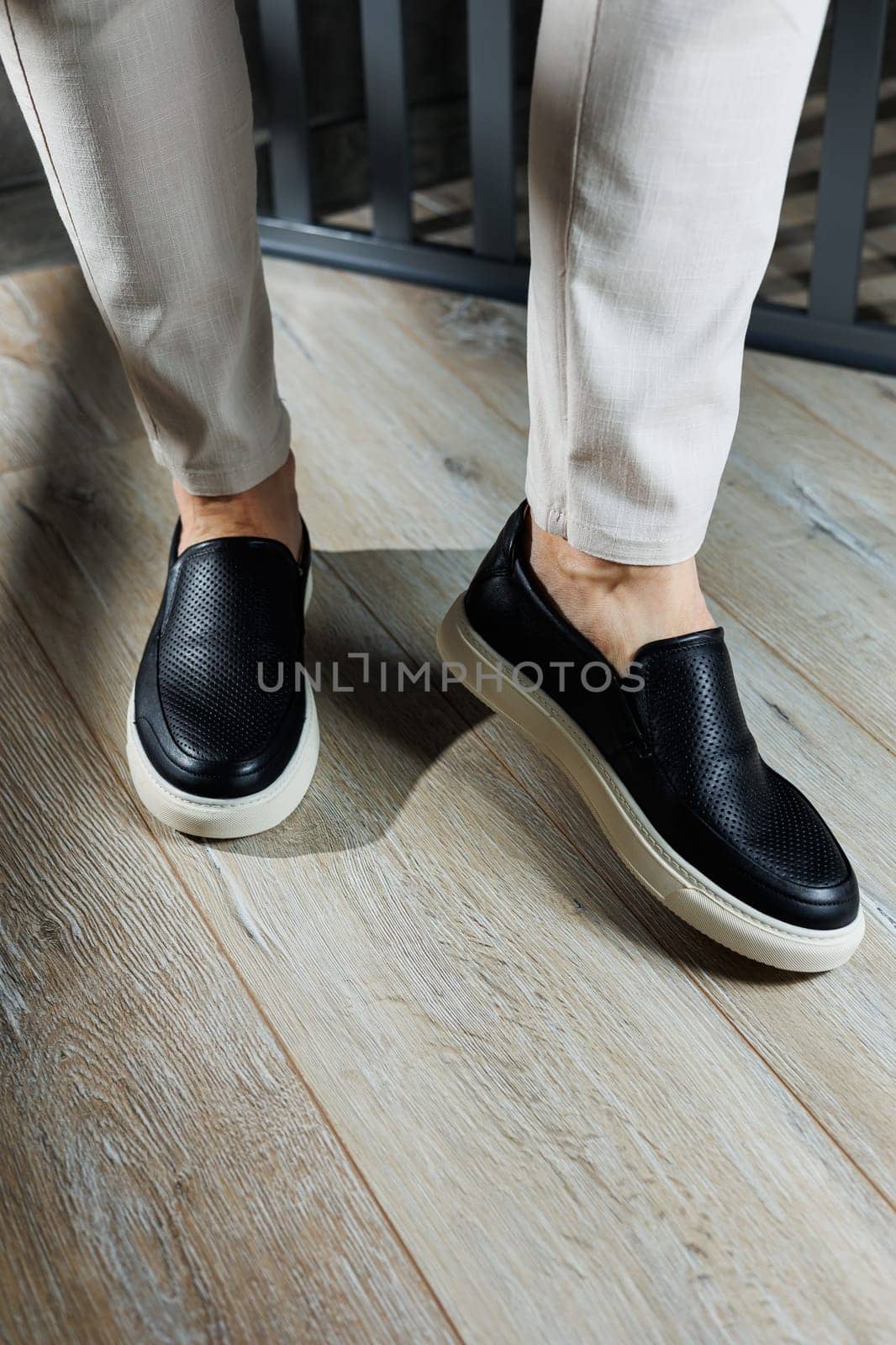 Male legs in leather shoes. Comfortable men's black shoes without laces. Casual men's moccasins