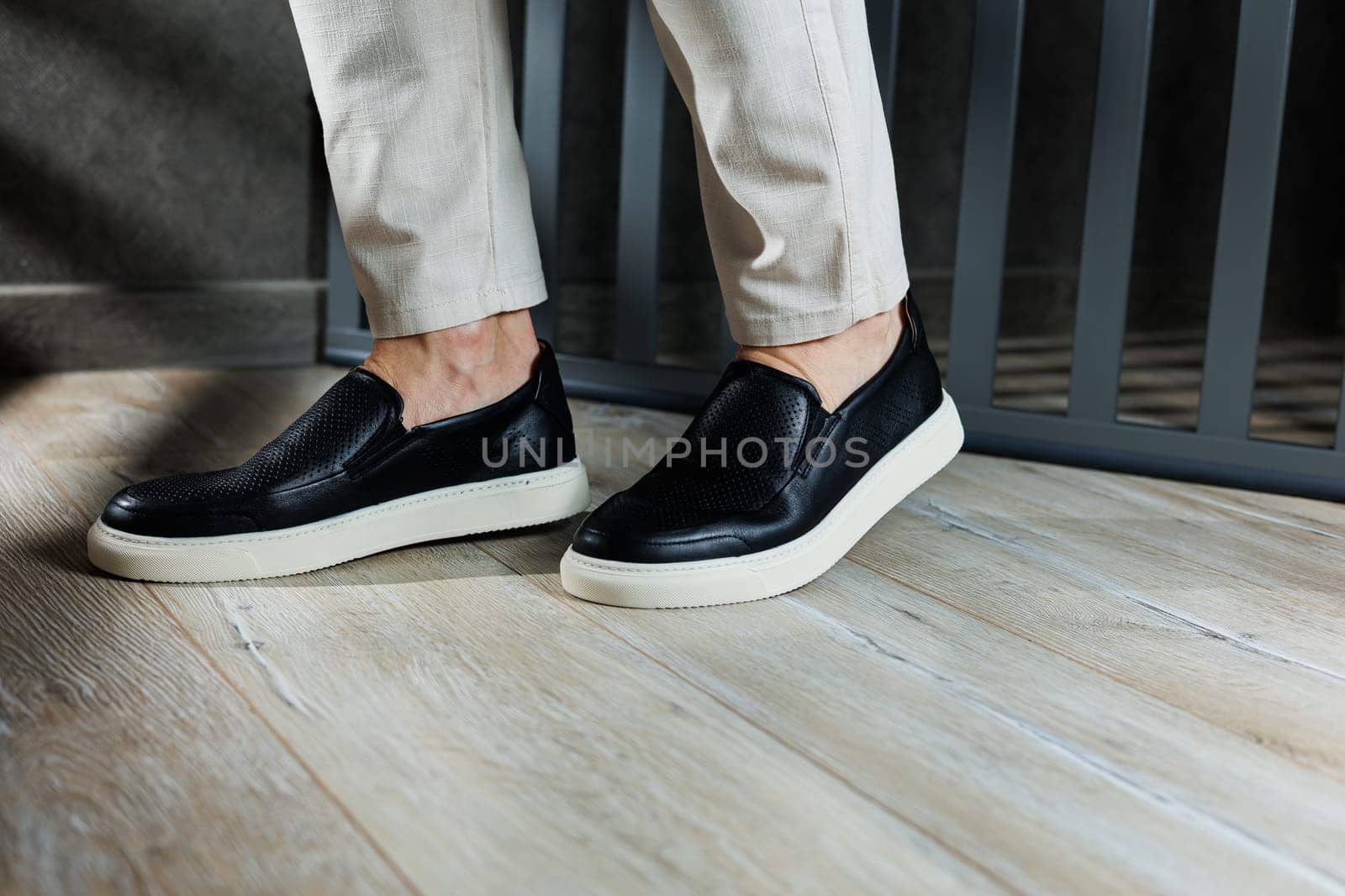 Male legs in leather shoes. Comfortable men's black shoes without laces. Casual men's moccasins