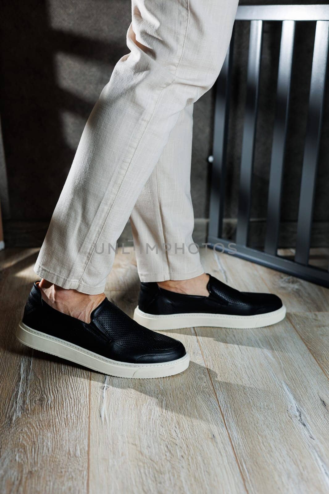 Male legs in leather shoes. Comfortable men's black shoes without laces. Casual men's moccasins