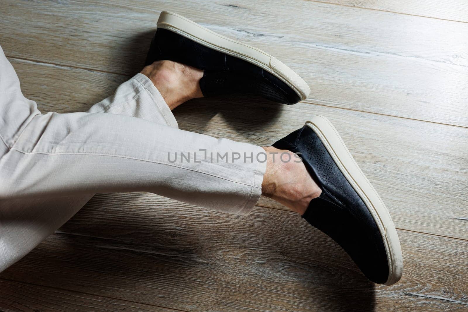 Male legs in leather shoes. Comfortable men's black shoes without laces. Casual men's moccasins