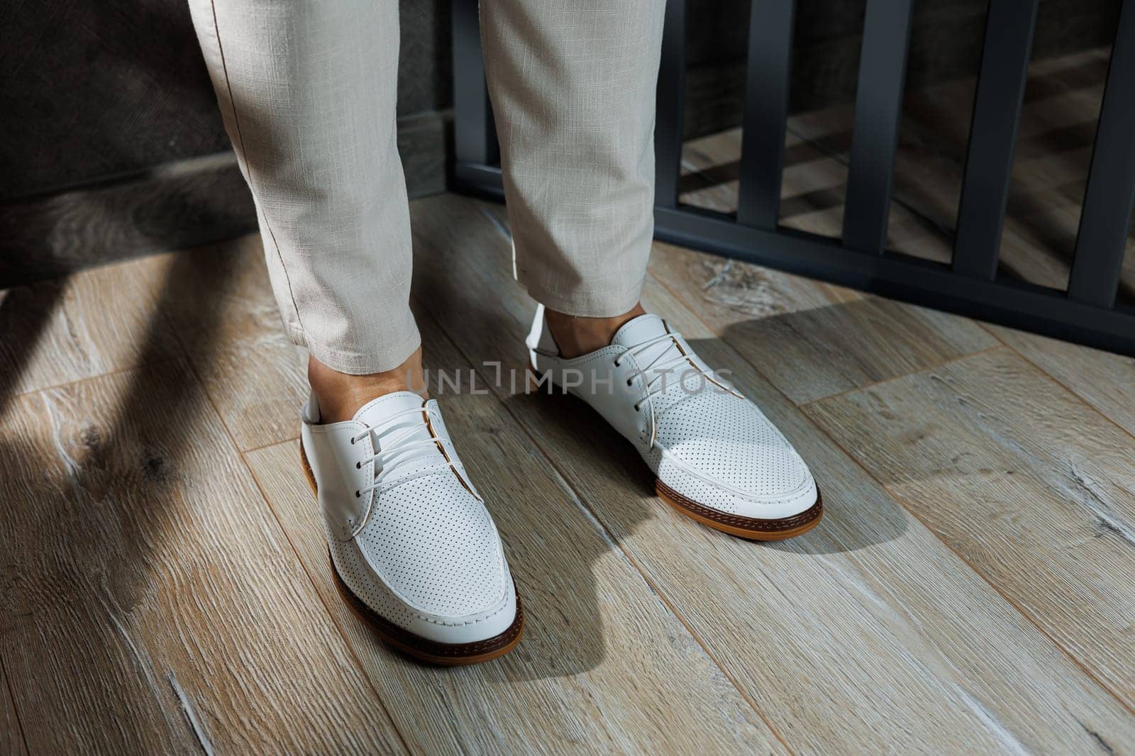 Male legs in leather summer shoes. Comfortable men's white moccasins without laces. Casual men's moccasins