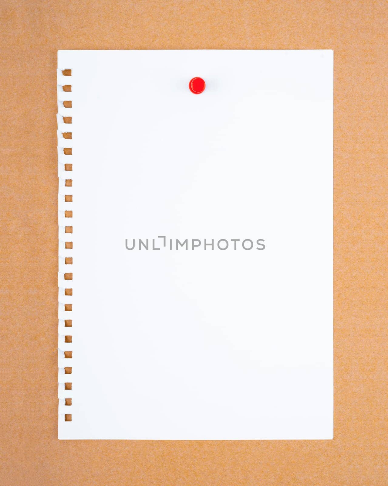 Blank white torn paper note with push pin on brown board background.