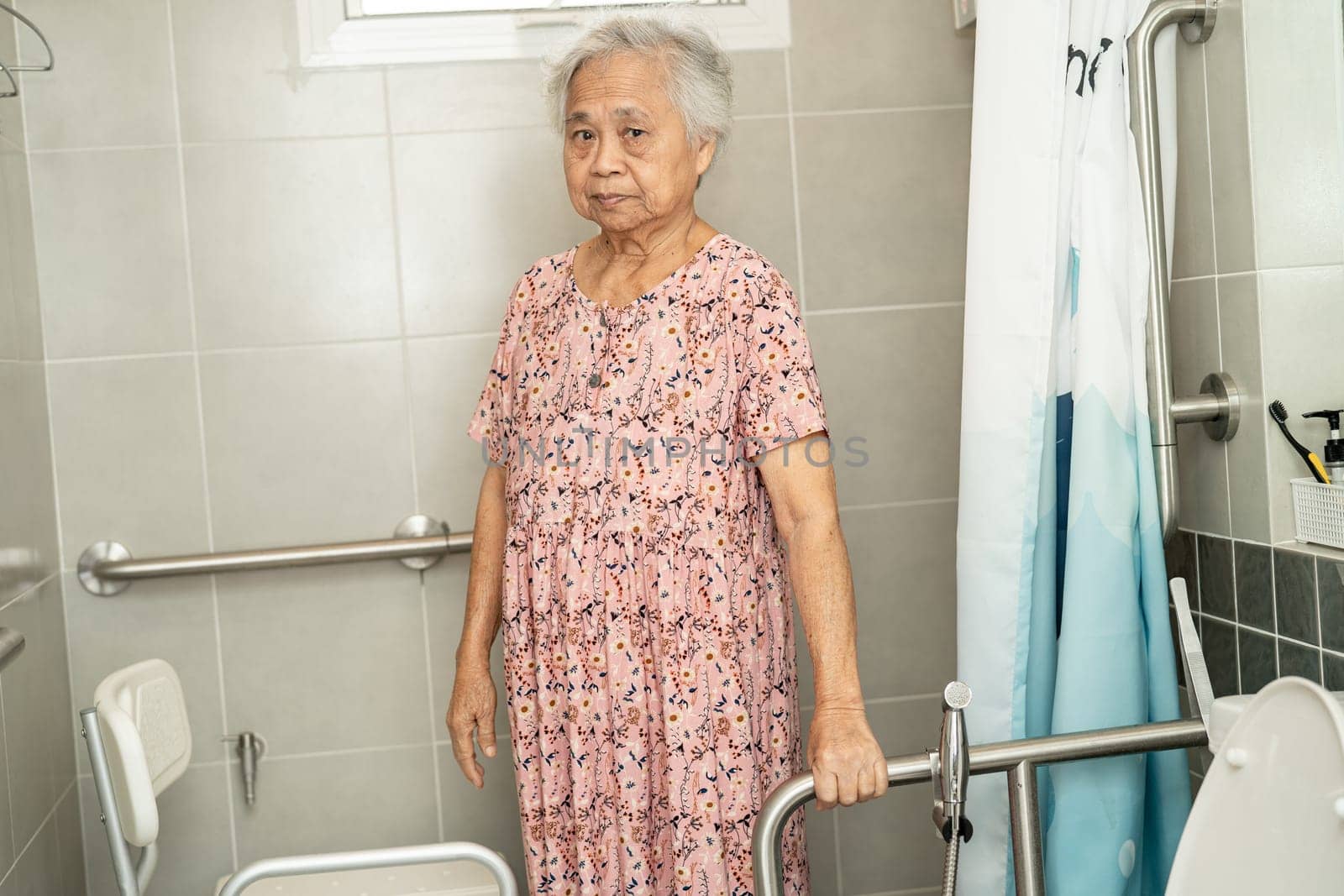 Asian elderly woman patient use toilet bathroom handle security in nursing hospital, healthy strong medical concept. by pamai