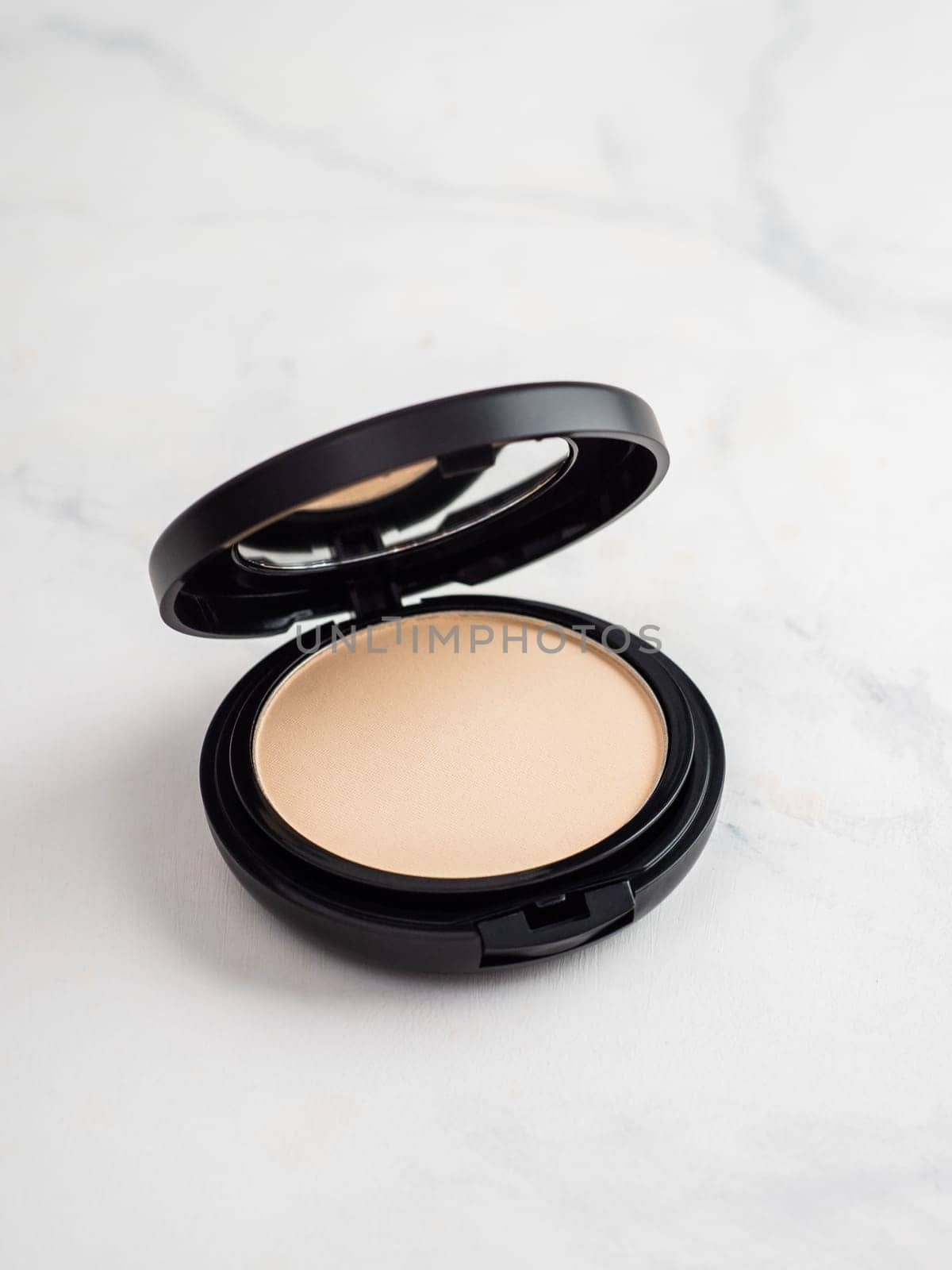 Compact powder on white marble, copy space by fascinadora