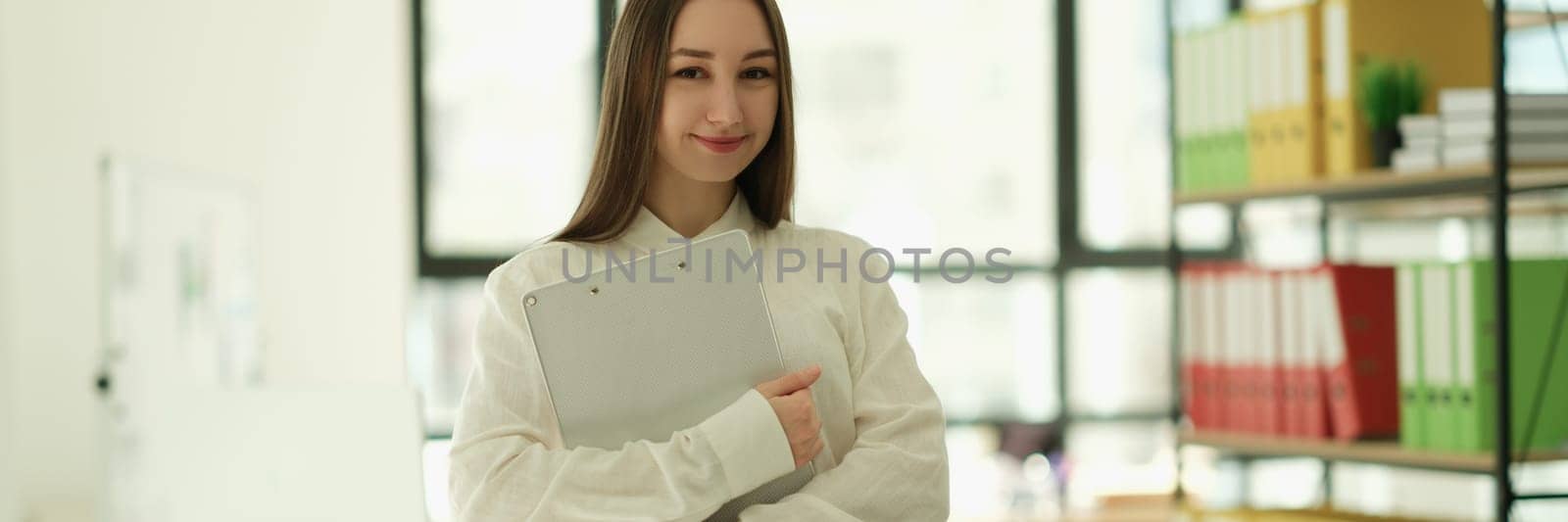 Woman manager with clipboard in hands in office portrait by kuprevich