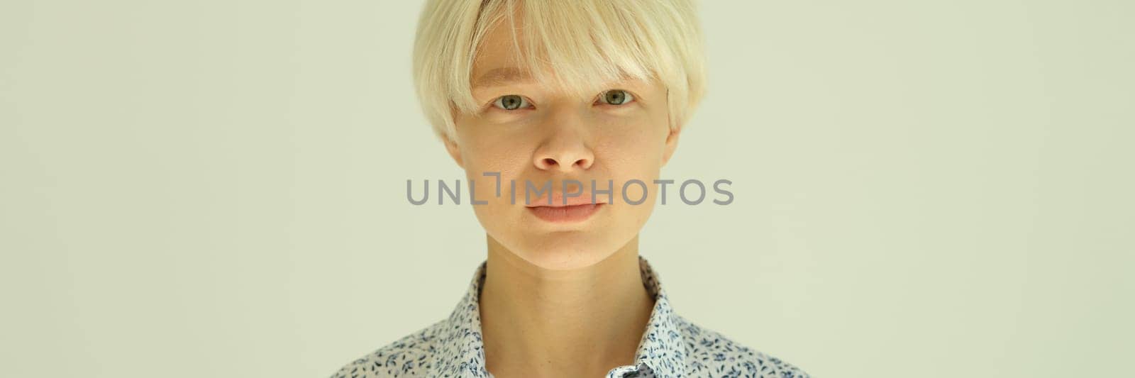 Portrait of young blonde woman with short haircut in shirt on white background. Stylish female hairstyles concept