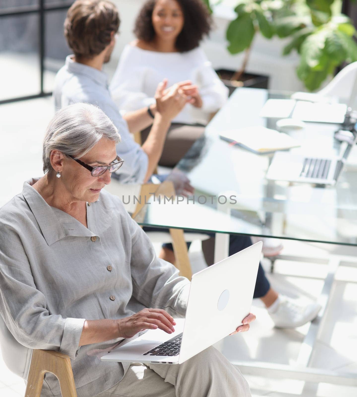 mature woman sitting and looking at laptop.