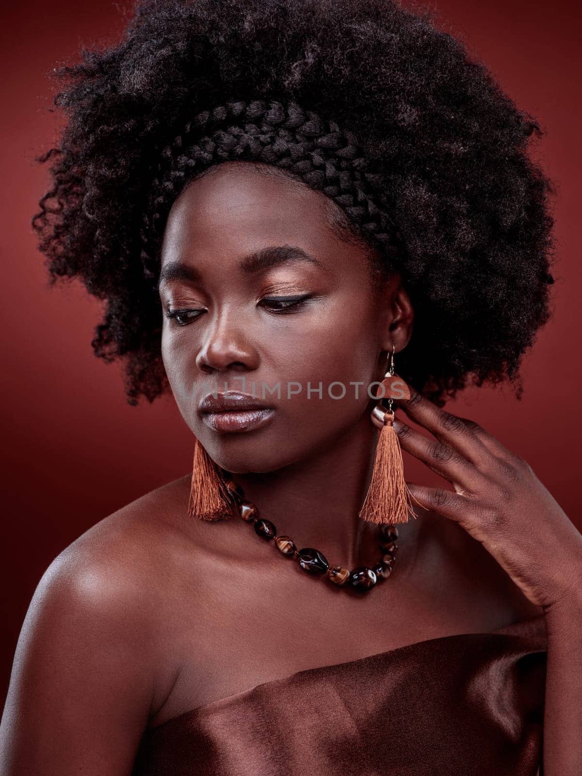 Beauty, natural skin and black woman in studio with glow on gradient, maroon or red background. Face, makeup and African lady model with culture, pride or cosmetic, isolated or style and aesthetic by YuriArcurs