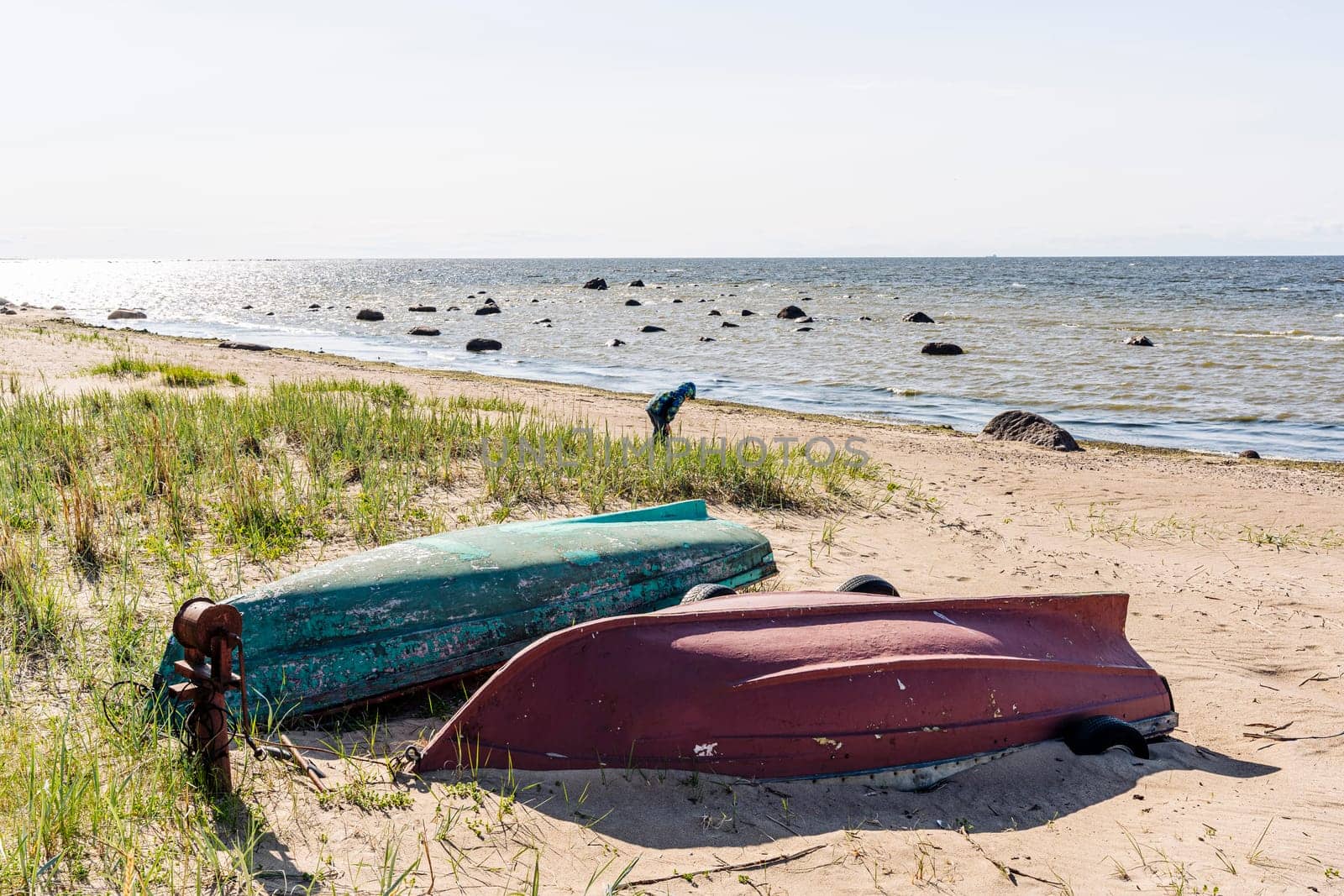 Old fishing boats pulled out on the sandy shore of the sea bay by audiznam2609