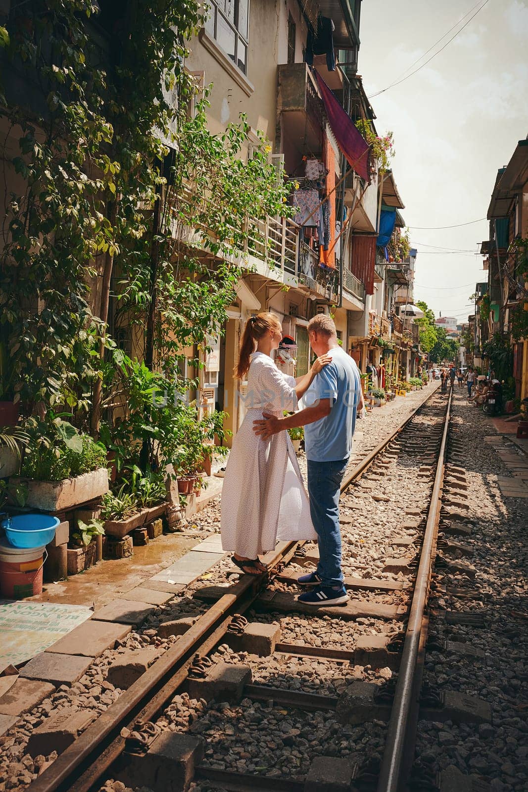 Nothing inspires romance like adventure. a happy couple sharing a romantic moment on the train tracks in the streets of Vietnam