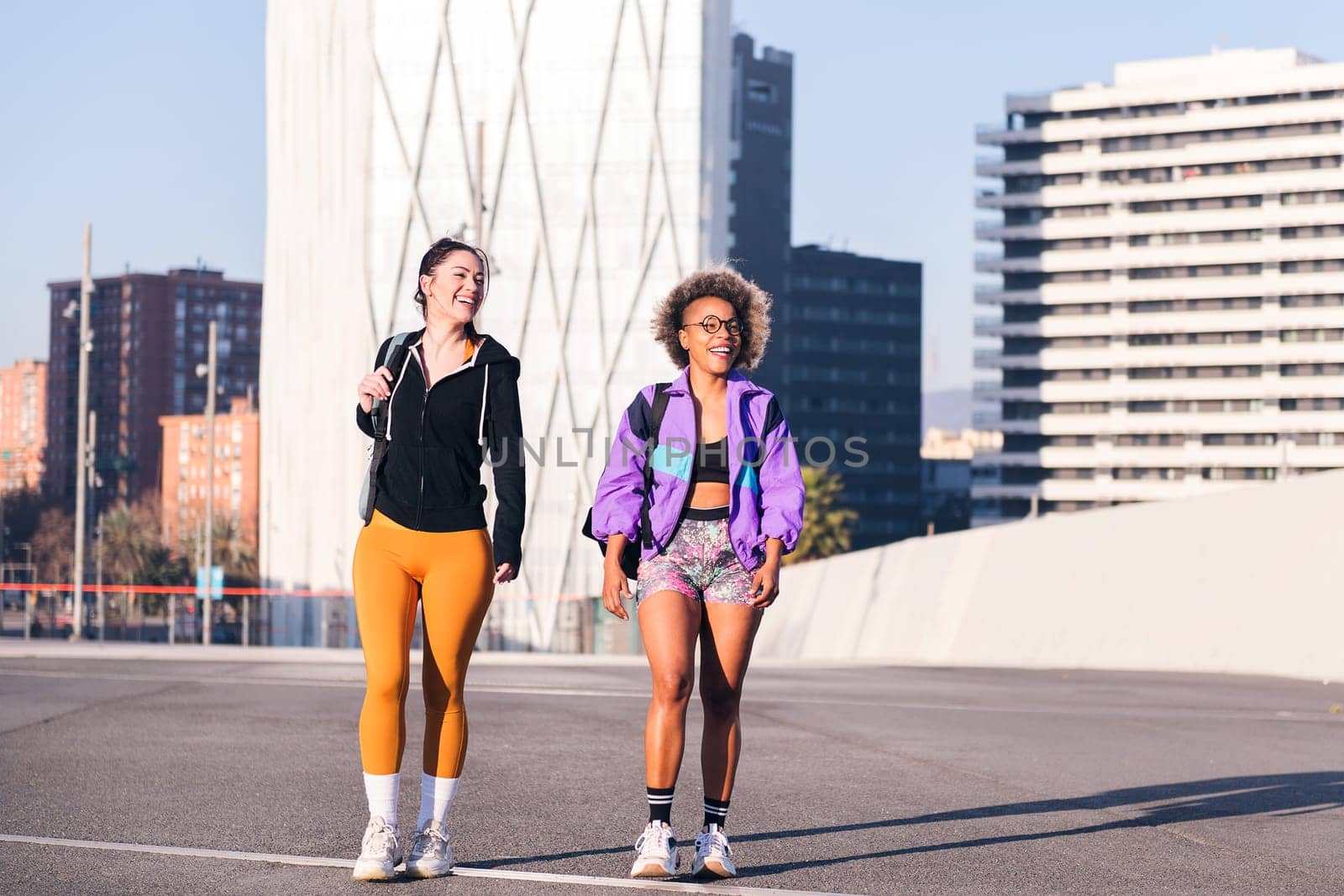 two friends walking along a city ready to run by raulmelldo