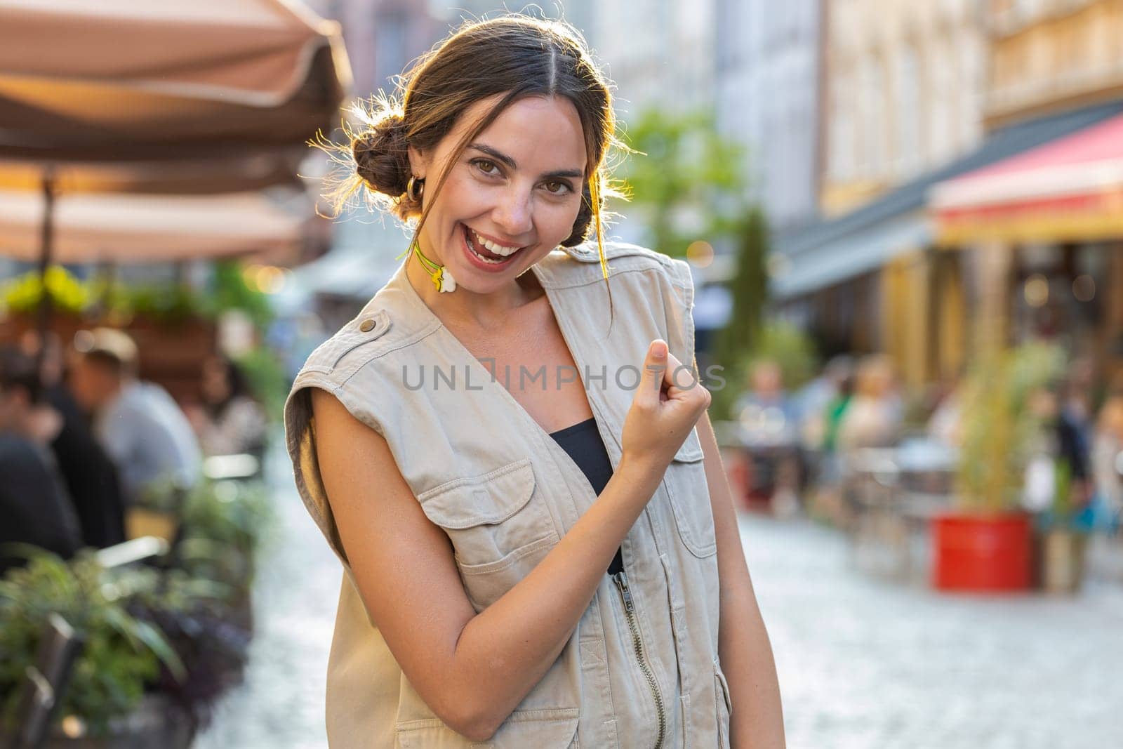 Portrait of pretty young woman shouting, celebrating success, winning, goal achievement, good news, lottery jackpot luck, victory outdoors. Girl walking on urban city summer street. Town lifestyles