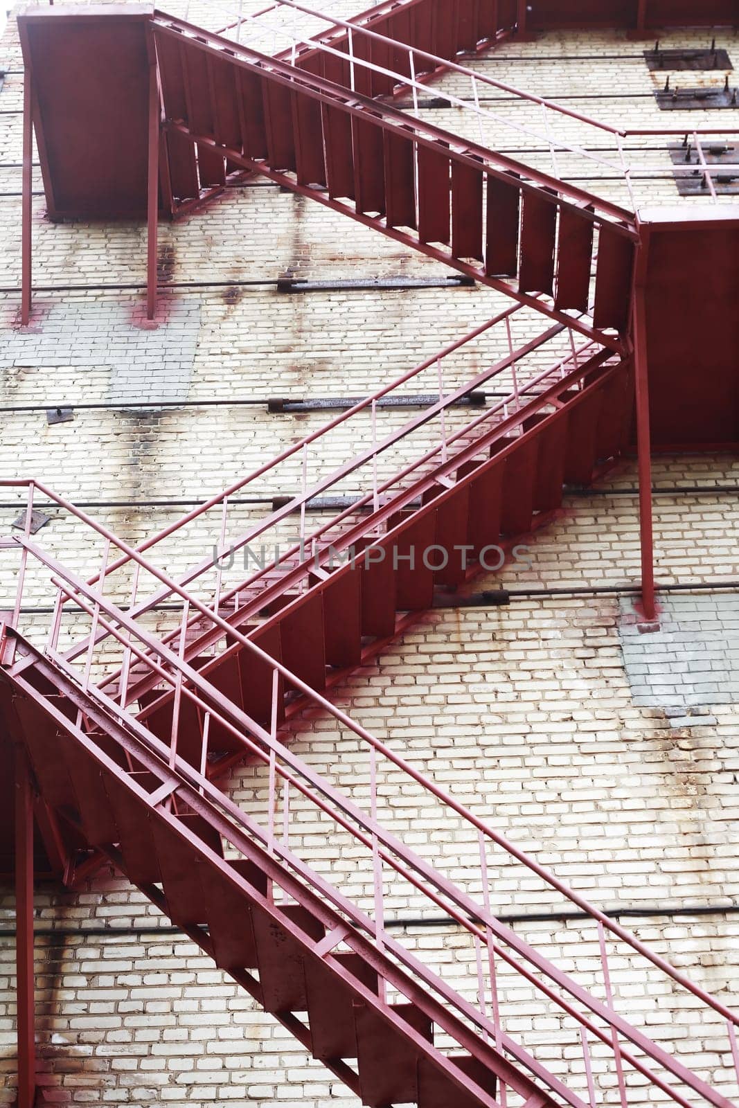 Industrial background. Closeup of high brick wall of old factory with fire escape