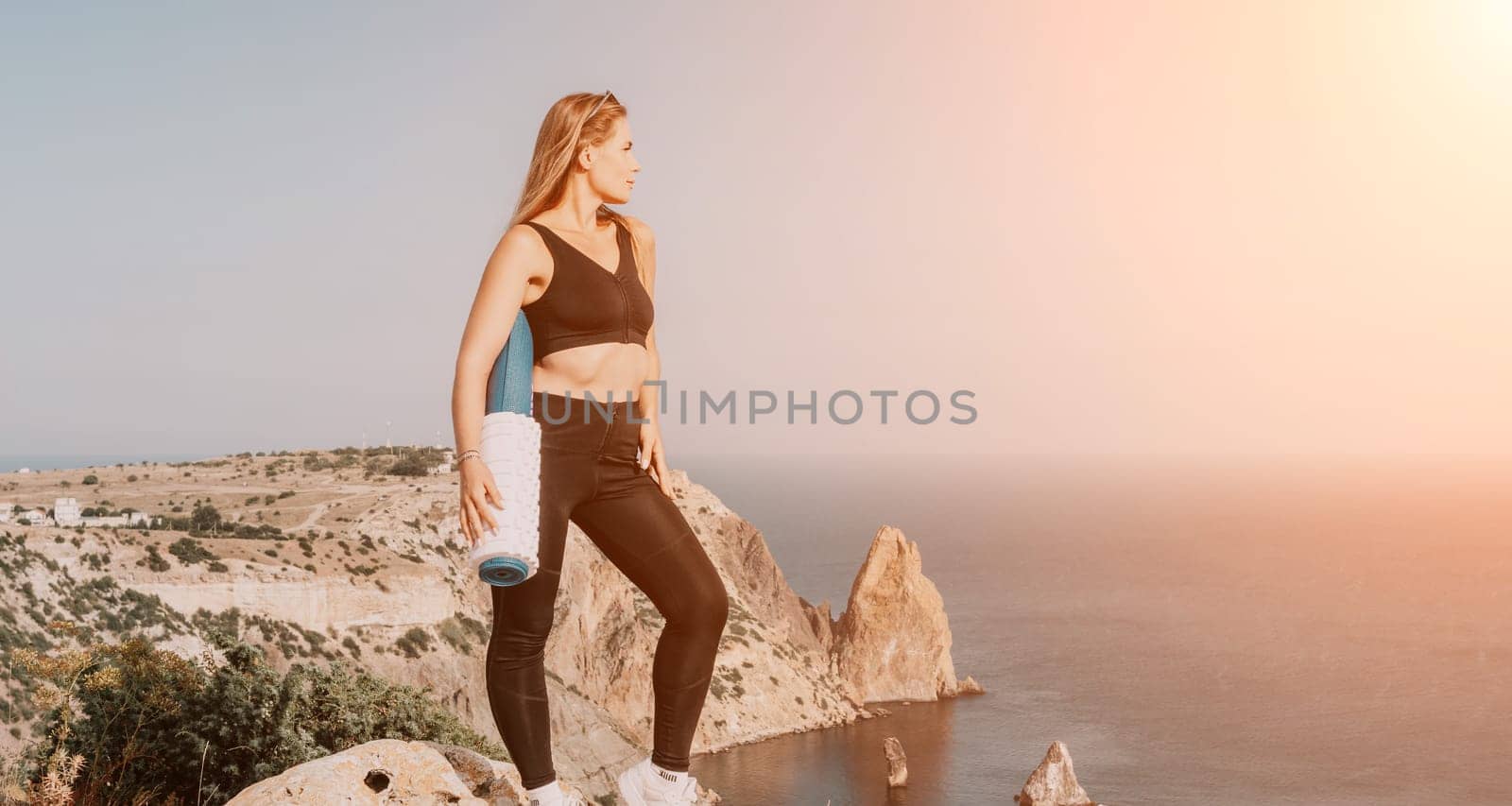 Fitness woman sea. Outdoor workout on yoga mat in park near to ocean beach. Female fitness pilates yoga routine concept. Healthy lifestyle. Happy fit woman exercising with rubber band in park.