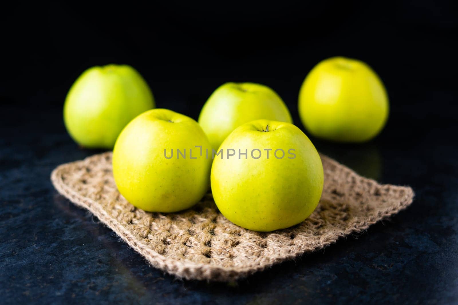 Ripe green apple fruits on a dark stone table. Top view with copy space. Flat lay