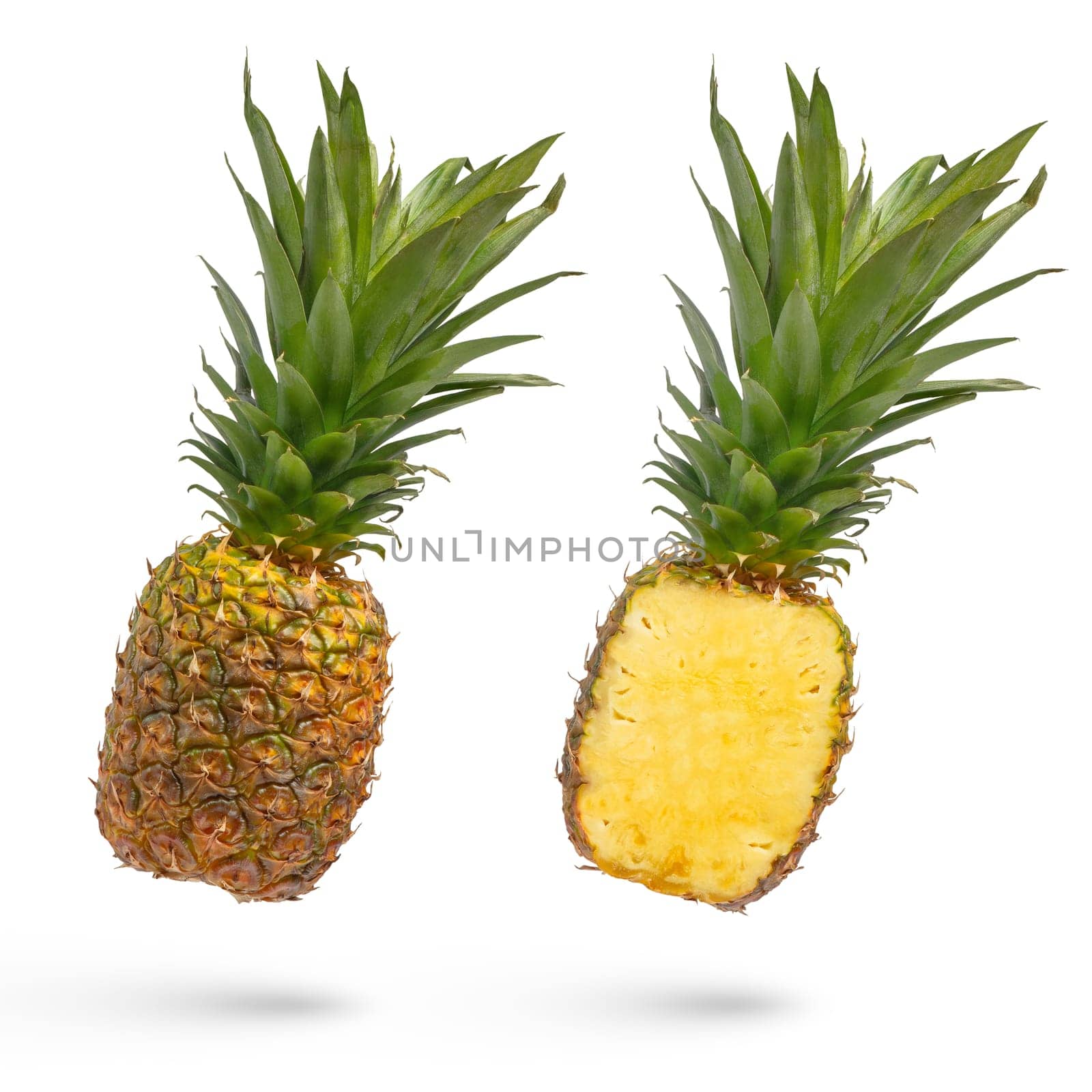 Whole unpeeled pineapple on a white isolated background. Juicy pineapple with peel and long green leaves, in two parts, cut lengthwise isolated on white. High quality photo