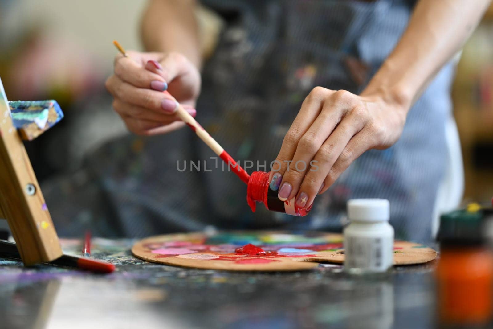 Closeup view of artist mixing color oil painting on palette. Art, hobby and leisure activity concept.