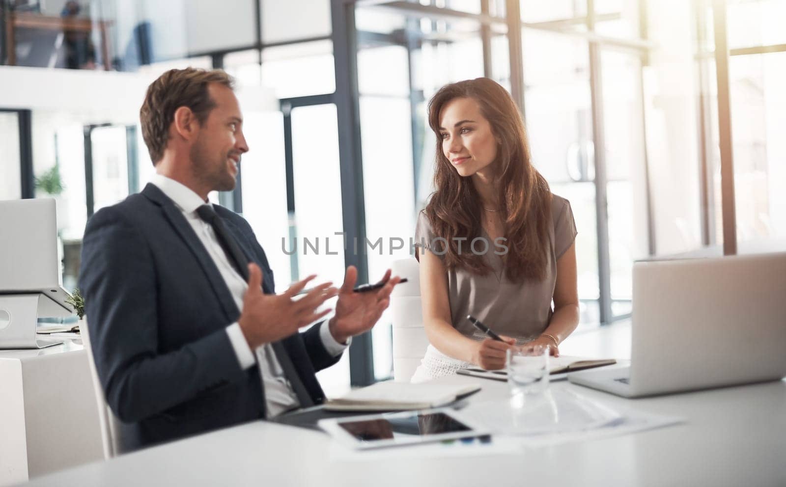 Laptop, collaboration or education with a mentor and employee in the boardroom for an introduction to the business. Teamwork, coaching or partnership with a male manager training a woman colleague by YuriArcurs