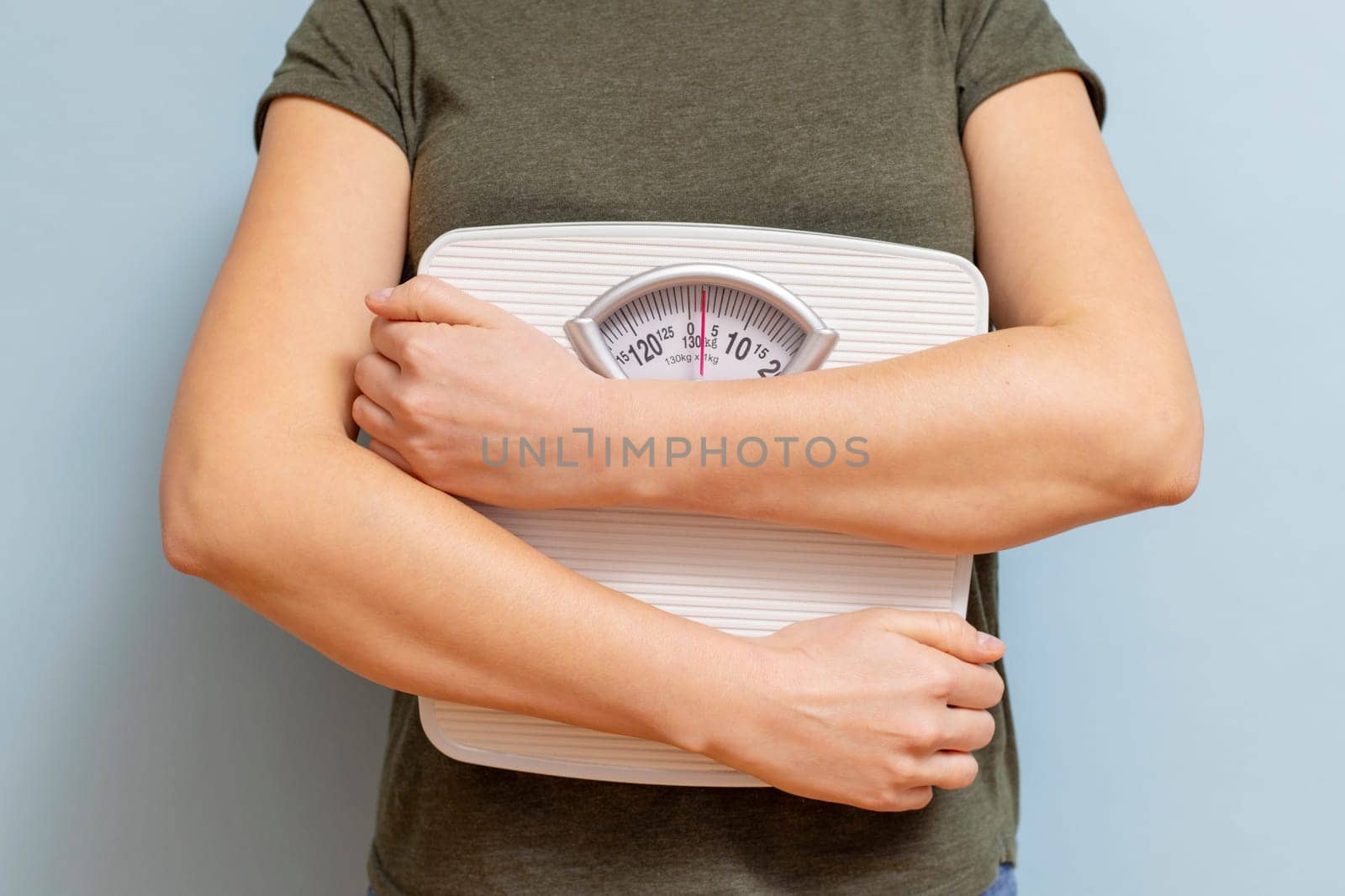 Young woman holding white scales to check the results of her diet . Diet and sport concept.