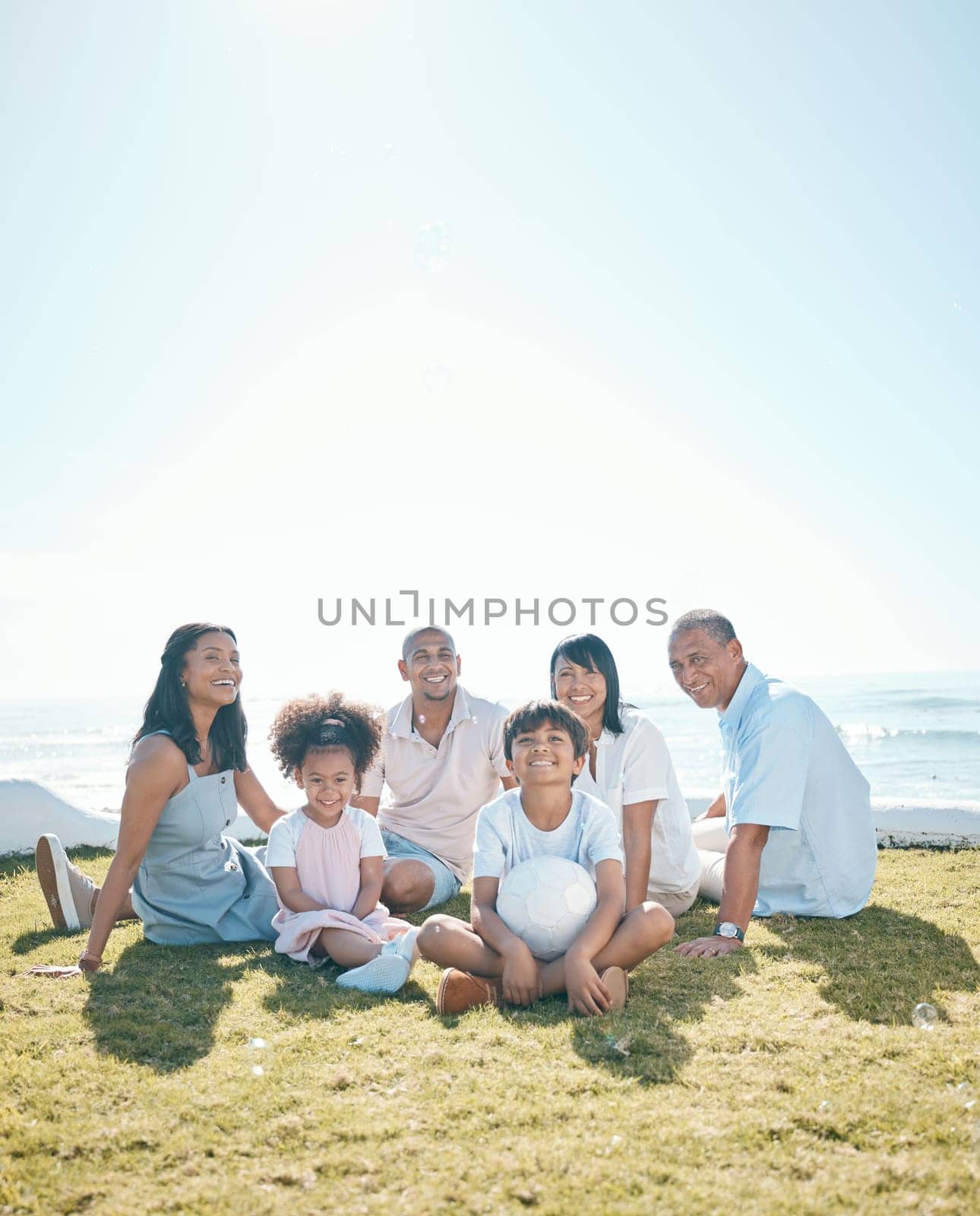 Generation, children and portrait sitting on grass in summer with ball for quality time on mockup space. Happiness, parents and big family in nature in garden for bond with love on holiday or house. by YuriArcurs