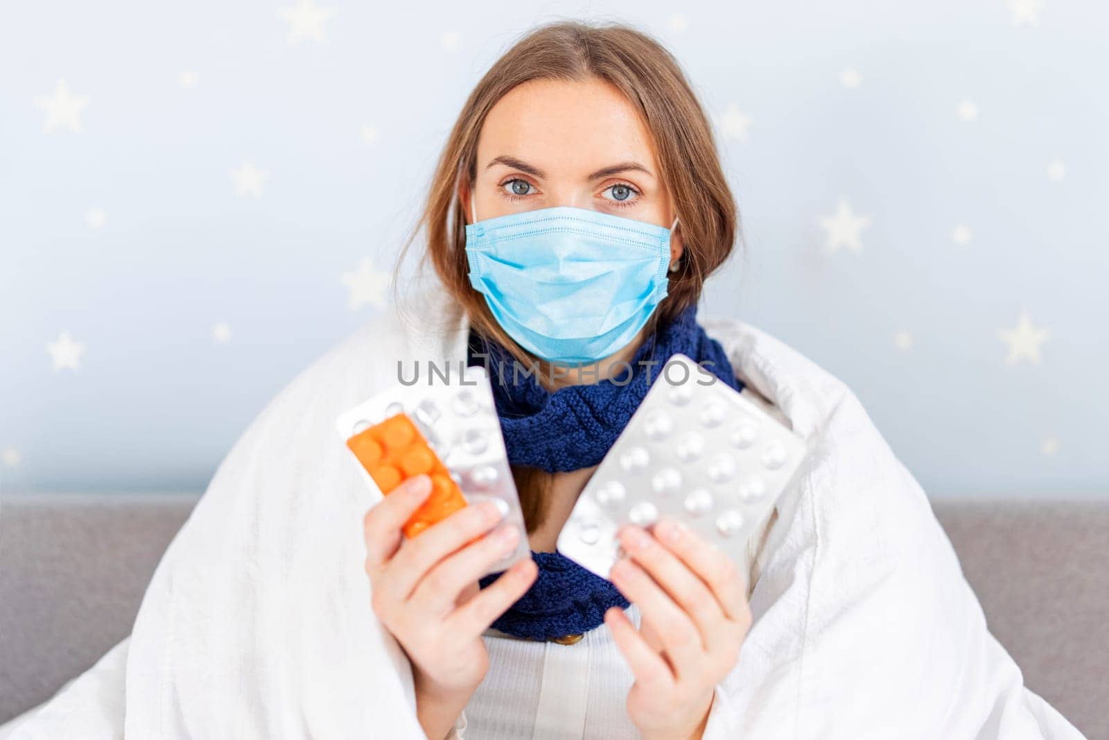 Sick woman in medical mask holding different medicines. Treatment of influenza or coronavirus during an epidemic.