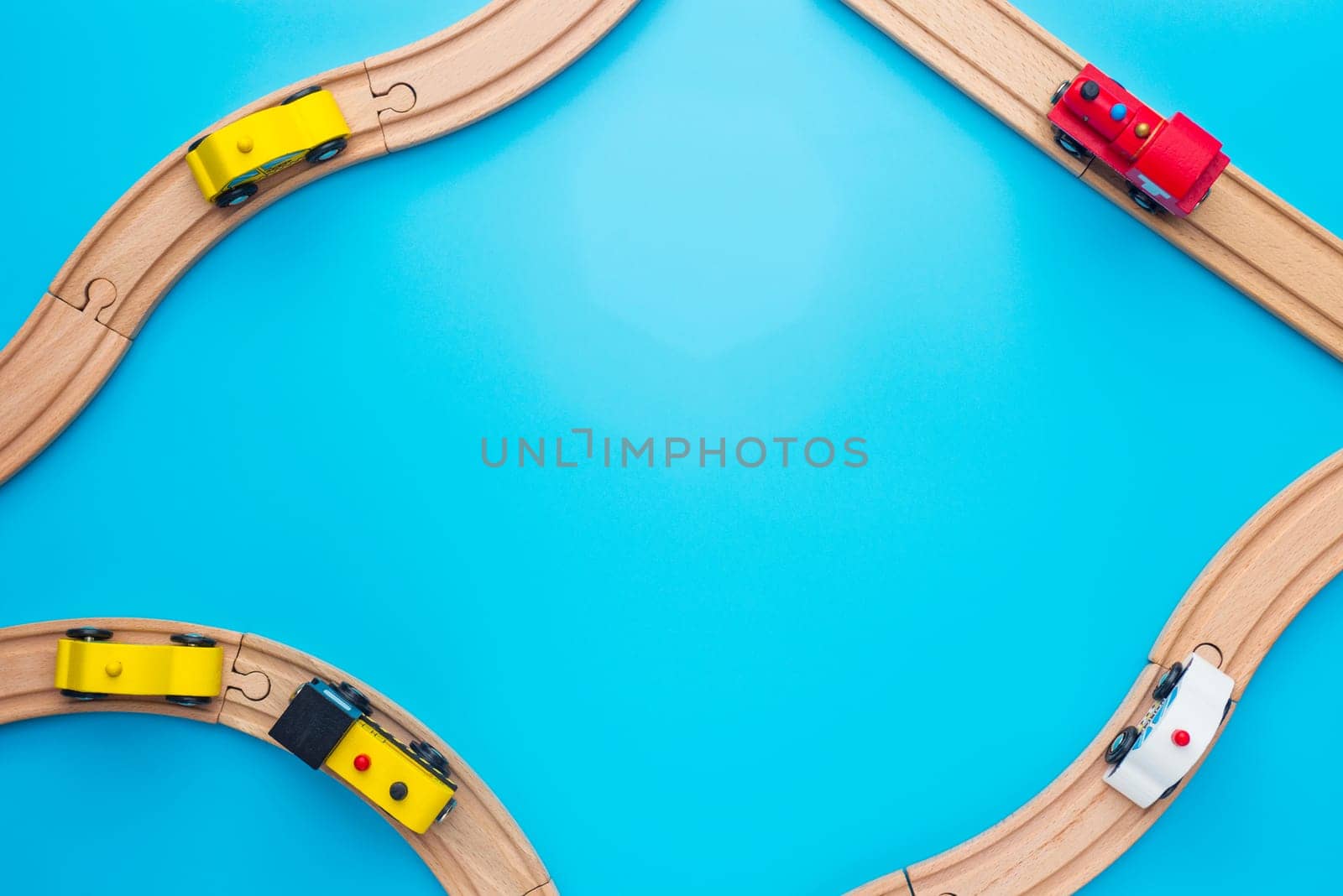 Baby kid toys background. Toy train and wooden rails on blue background. Top view.
