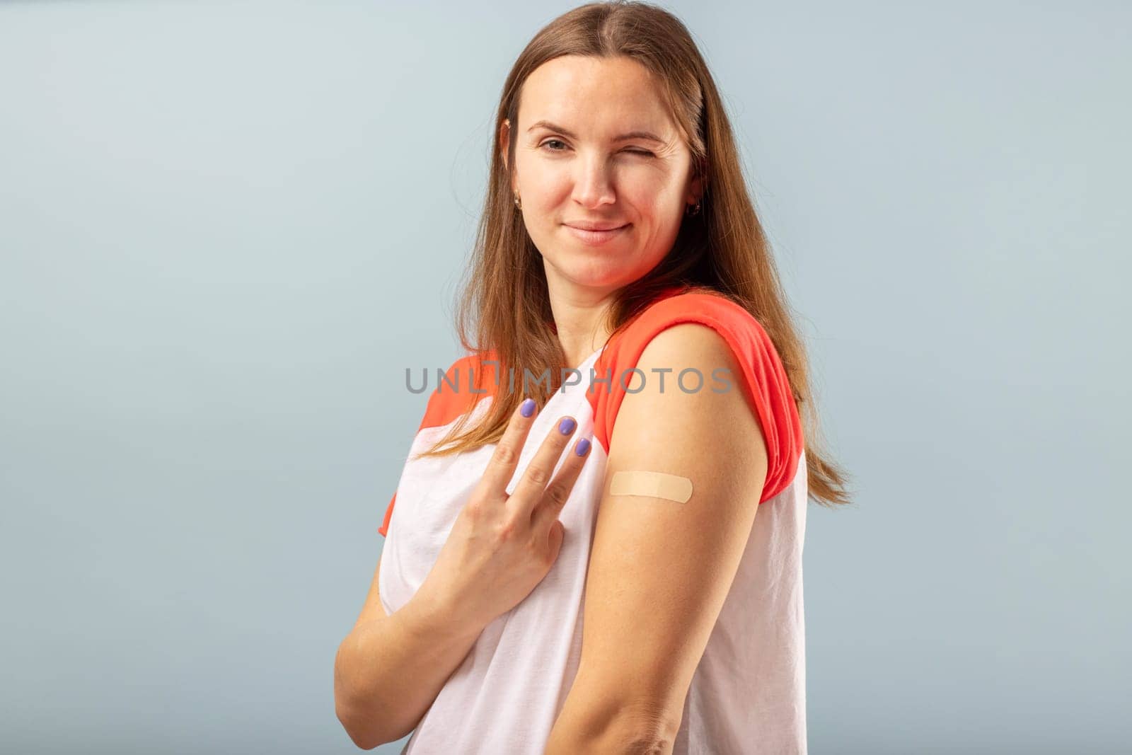 Coronavirus vaccination advertisement. Happy vaccinated woman after injection of third booster dose of coronavirus. Vaccination COVID-19.