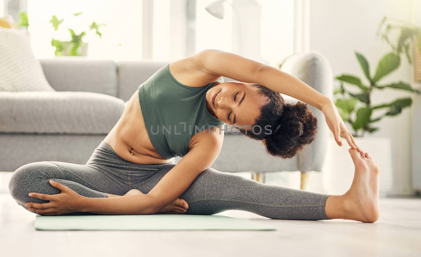 Yoga, stretching and woman on a living room floor for training, exercise or mental health at home. Leg, stretch and female with flexible fitness or pilates workout for balance, meditation or wellness by YuriArcurs