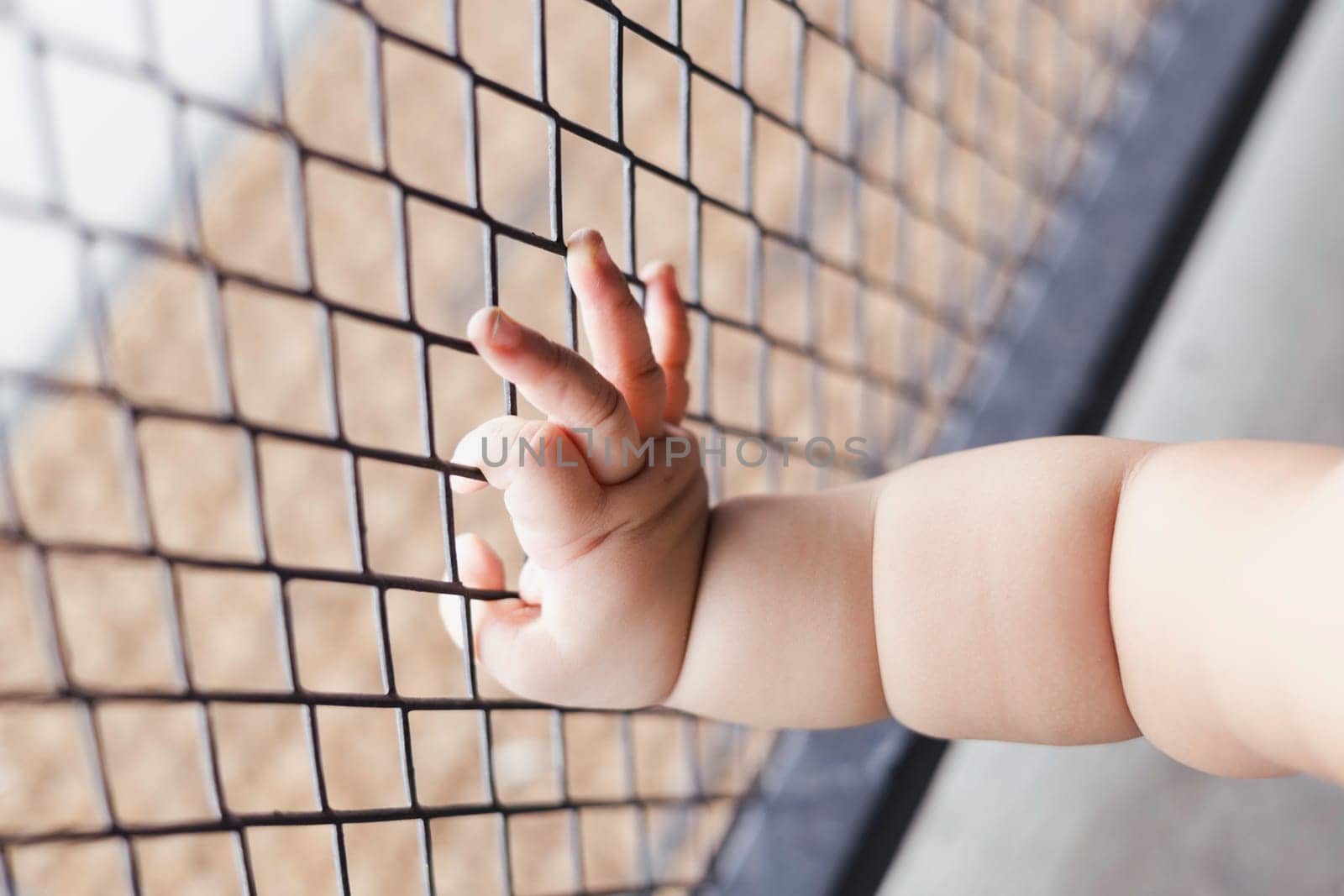 Children Hand With Steel Cage background for advertisement and wallpaper in baby safety and protection scene. Actual images in decorating ideas