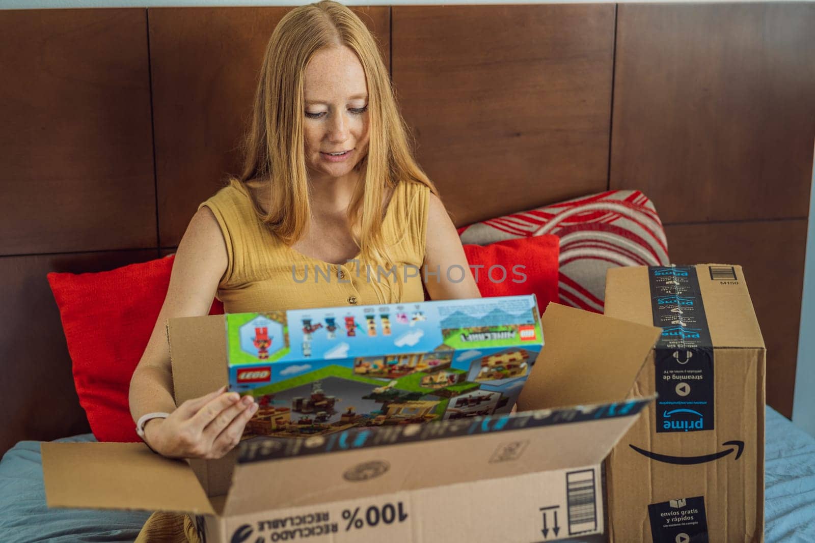 12.21.22, Mexico, Playa del Carmen: A pregnant woman received a package from Amazon. A woman takes a Lego set out of the box for her eldest son. Online shopping during pregnancy.