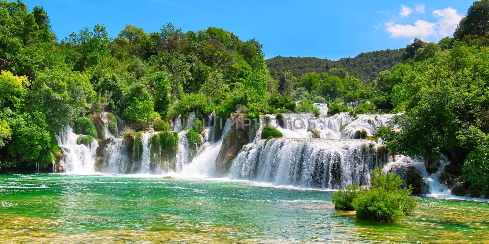 Beautiful Waterfall background in sunny summer day. Beautiful Waterfall In Krka National Park - Croatia, Europe. Krka river waterfalls in the Krka National Park