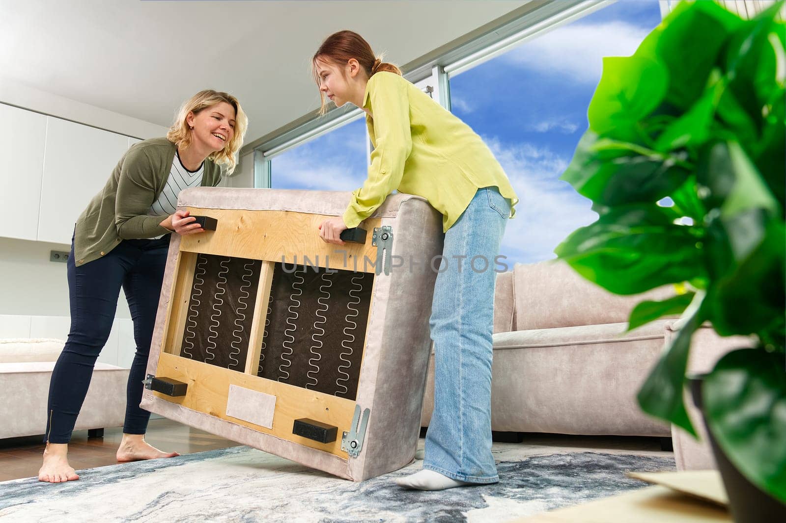 Family rearranging furniture Happy couple moving furniture in new apartment. Moving day happy buyers by PhotoTime