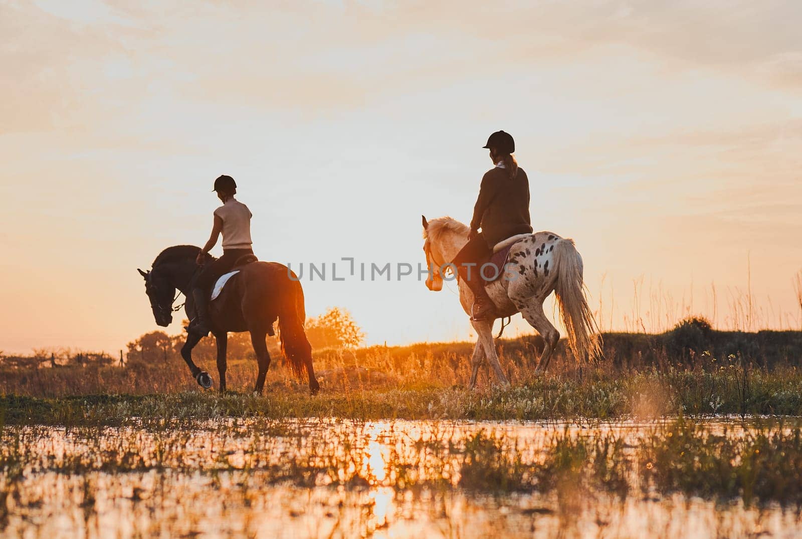 Horseback, women and friends by lake in countryside at sunset with outdoor mockup space. Equestrian, girls and animals in water, nature and adventure to travel, journey or summer vacation together by YuriArcurs