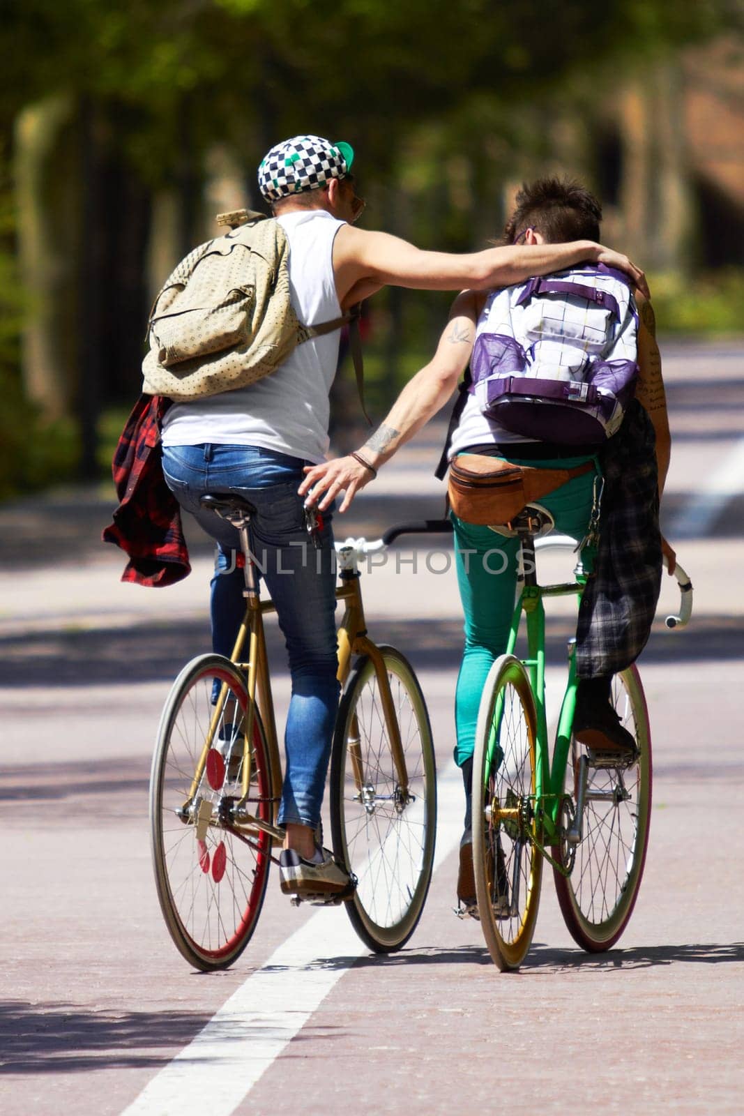 Men, students and friends with back, bicycle and sustainable transportation on road in summer sunshine. Young gen z people, eco cycling and outdoor together in street with travel on university campus by YuriArcurs