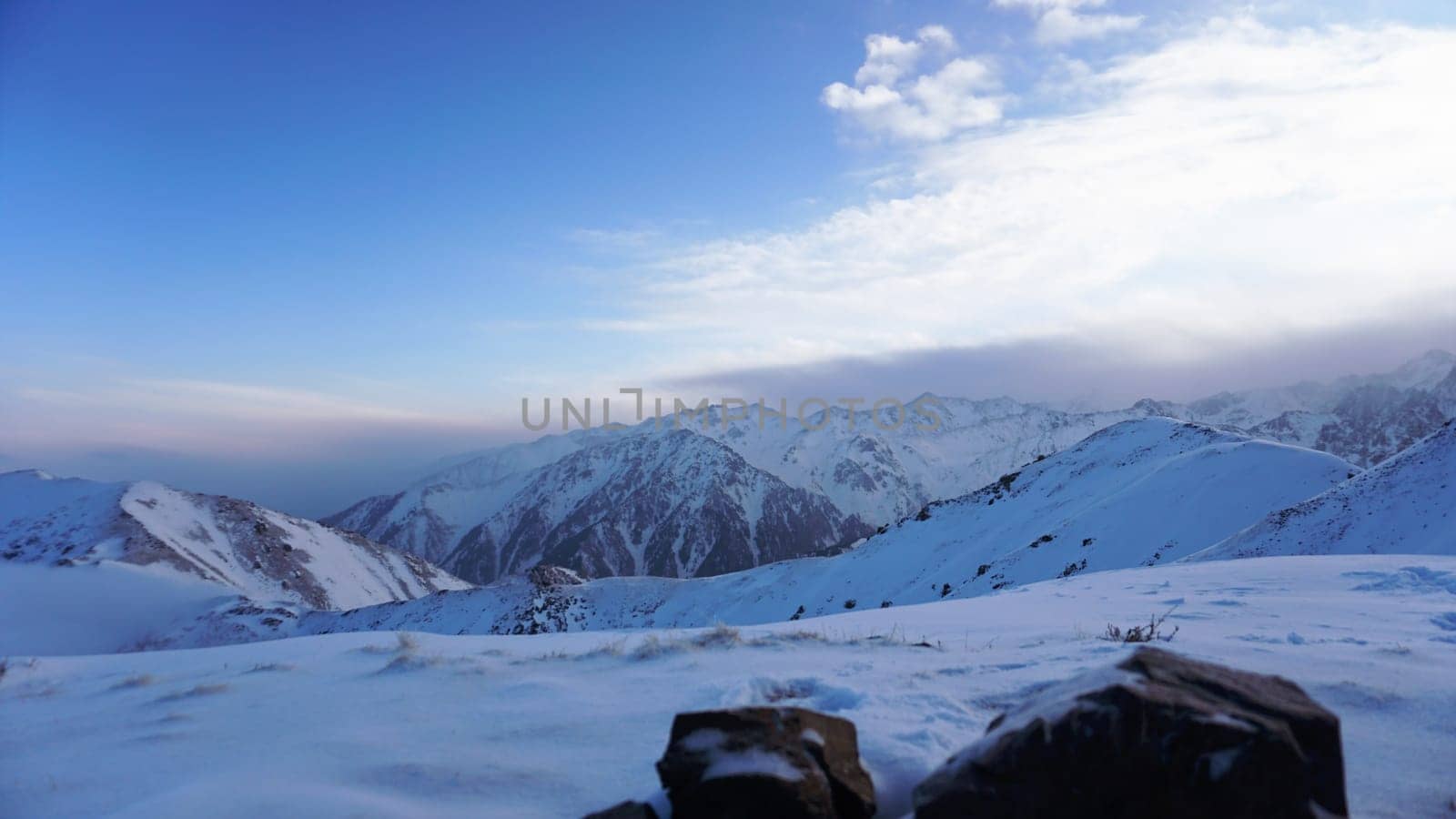 Ocean of clouds in snowy mountains at dawn by Passcal