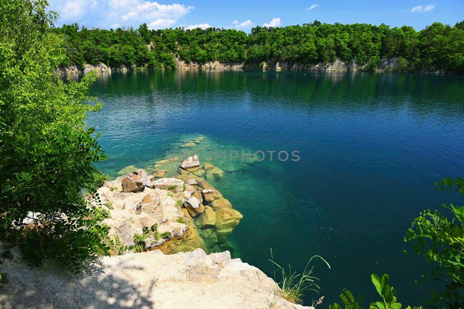 Beautiful flooded quarry with clear water for swimming. Summer landscape concept with nature. Masovice - Czech Republic.