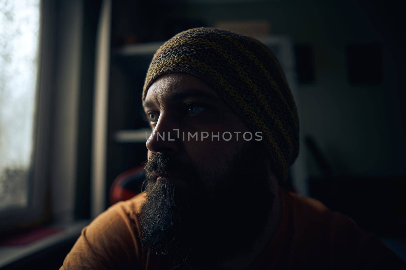 A man with a beard wearing a striped hat and t-shirt by snep_photo