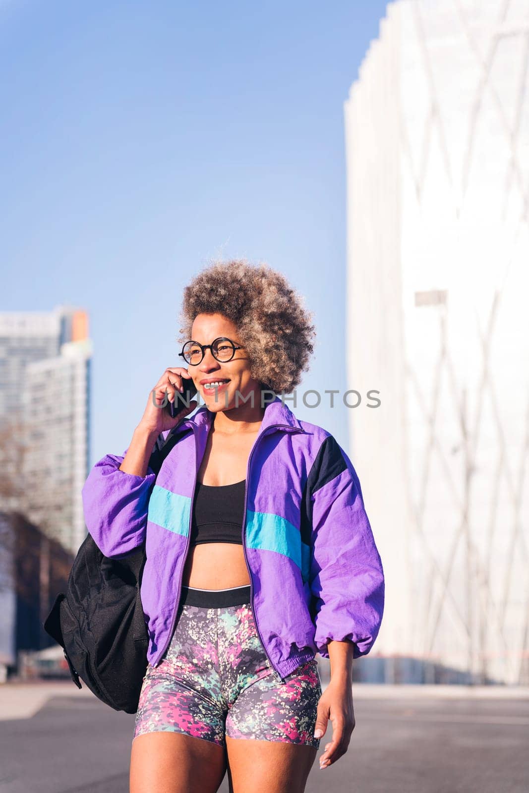 woman in sportswear talking by phone in the city by raulmelldo