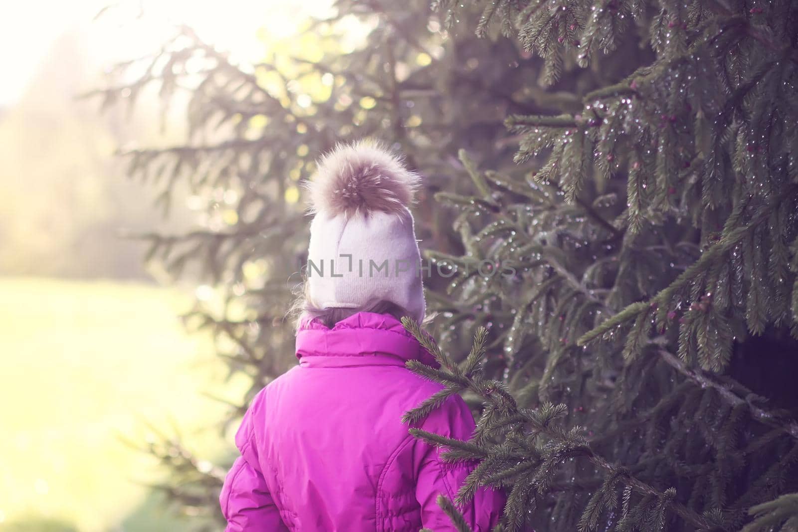 Little girl walks outdoors in sunny day. Early spring in countryside.